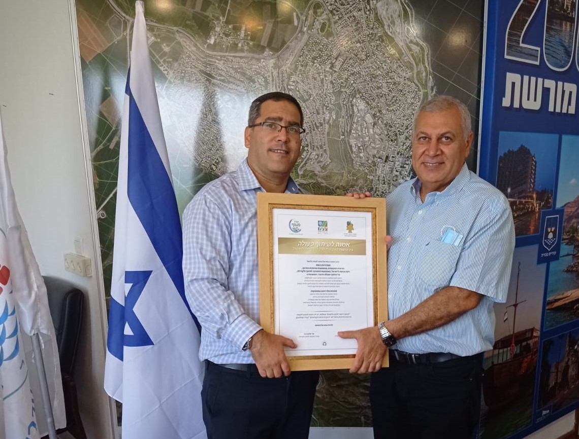 תמונה של בועז יוסף ושר שלום גרבי אוחזים את התעודה